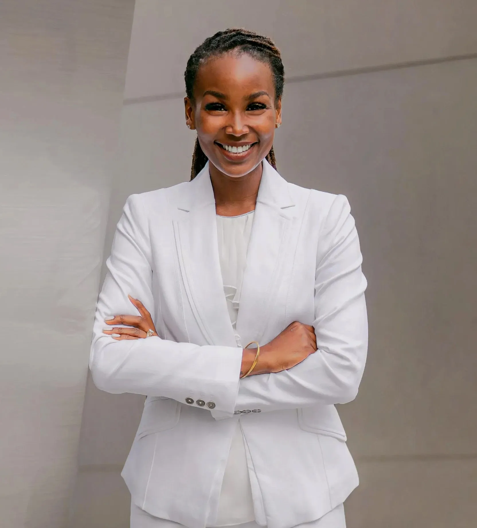 A woman wearing a white suit and smiling.